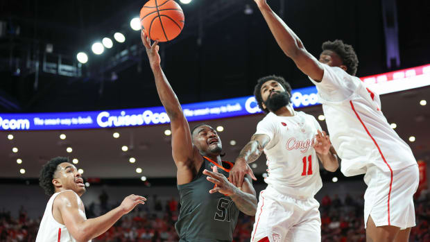 Feb 6, 2024; Houston, Texas, USA; Oklahoma State Cowboys guard John-Michael Wright (51) shoots the ball as Houston Cougars guard Damian Dunn (11) defends during the first half at Fertitta Center. Mandatory Credit: Troy Taormina-USA TODAY Sports